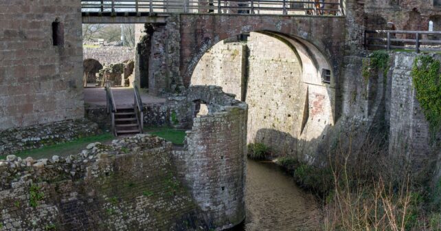 A detailed view of the stone archway and moat at Raglan Castle in Wales.